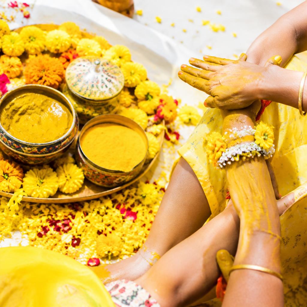 Turmeric bowls and marigolds at a haldi ceremony